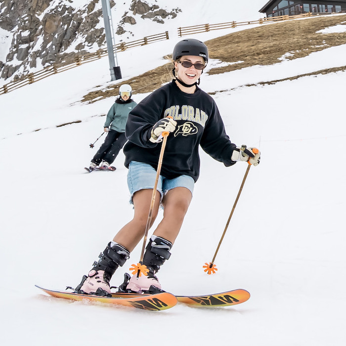 Smiling skier making a turn on a gentle slope.