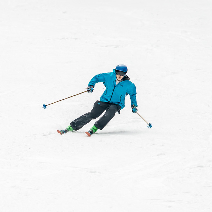 Skier leaning deeply into a turn.