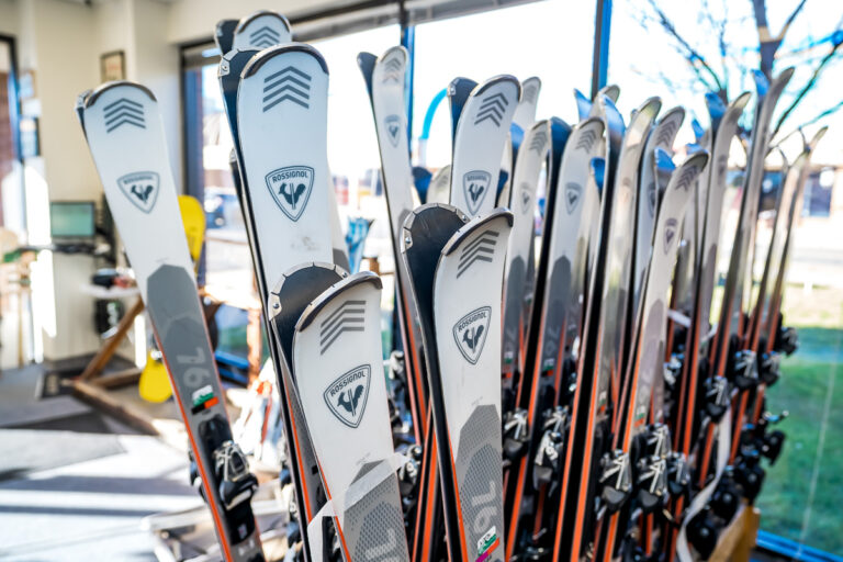 Rossignol rental skis in wooden rack.