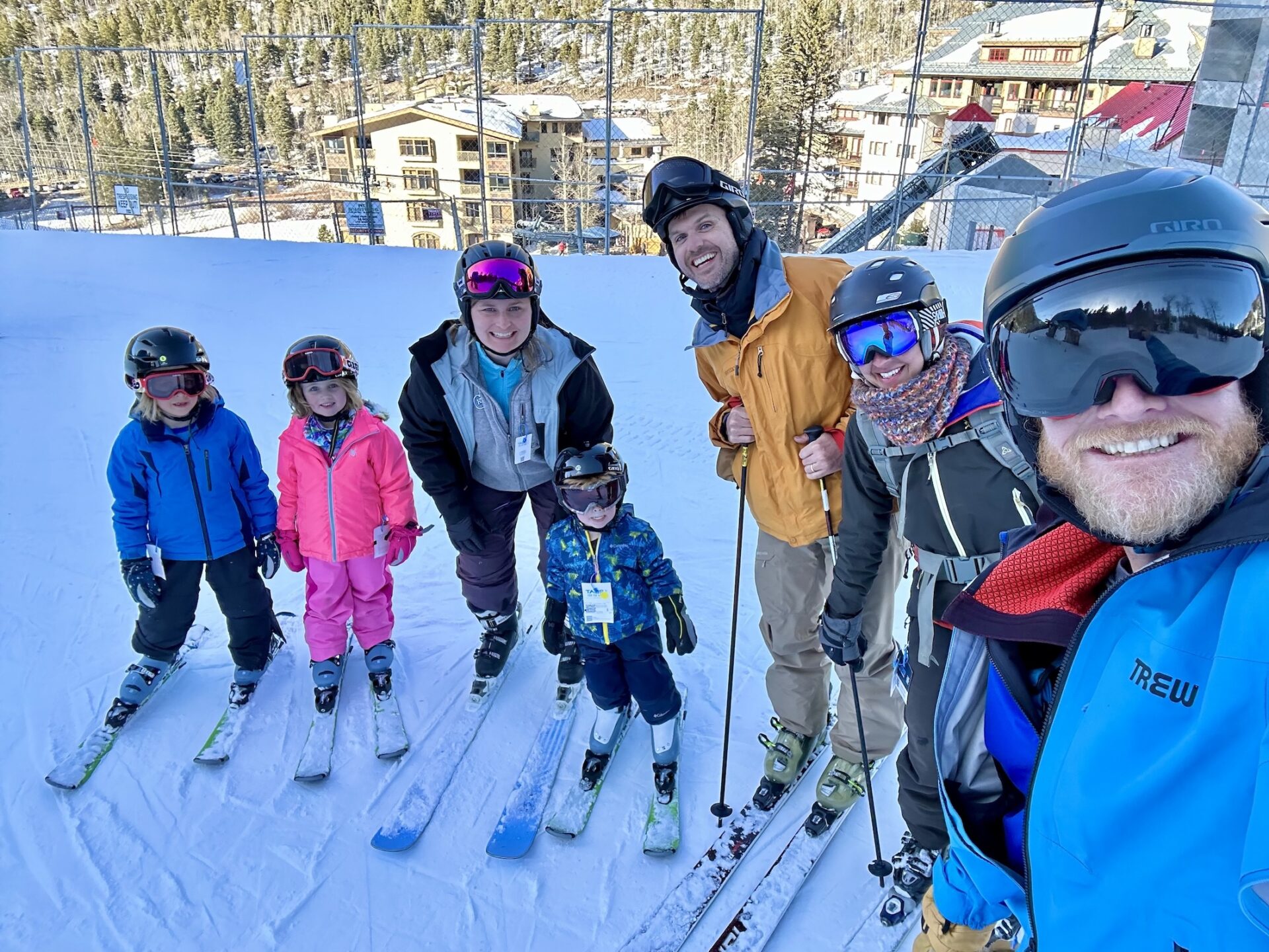 Smiling group of parents and kids on skis.